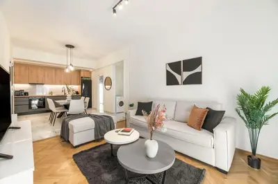 a living room with a white couch and a table at Adorable 2BR Apartment in Neos Kosmos by UPSTREET in Athens