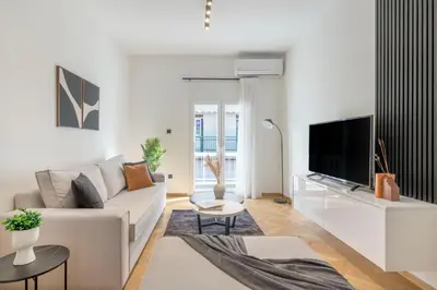 a white living room with a couch and a tv at Adorable 2BR Apartment in Neos Kosmos by UPSTREET in Athens
