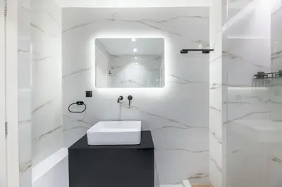 a white bathroom with a sink and a mirror at Adorable 2BR Apartment in Neos Kosmos by UPSTREET in Athens
