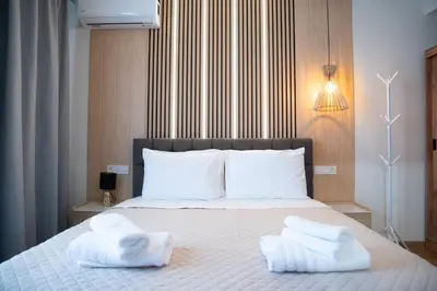 a bedroom with a bed with two towels on it at Niki Athens Suites - Sunny Suite at Historical Centre Monastiraki in Athens