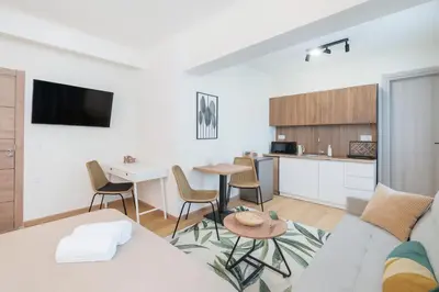 a living room with a couch and a table and a kitchen at Niki Athens Suites - Sunny Suite at Historical Centre Monastiraki in Athens