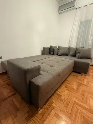 a large couch in a room with wooden floors at Angel Home in Athens