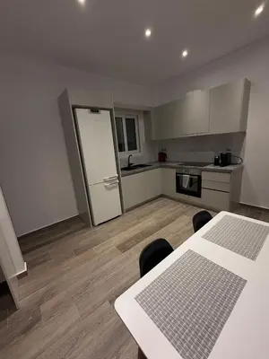 a kitchen with a table and a white refrigerator at Angel Home in Athens