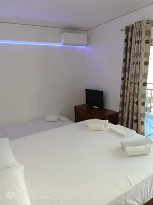 a bedroom with a white bed and a television at Anis Apartments 2 in Athens