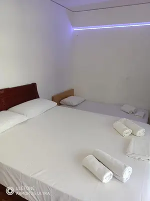 a white bed with two rolled towels on it at Anis Apartments 2 in Athens