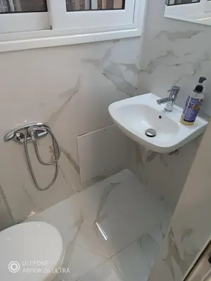 a white bathroom with a sink and a toilet at Anis Apartments 2 in Athens