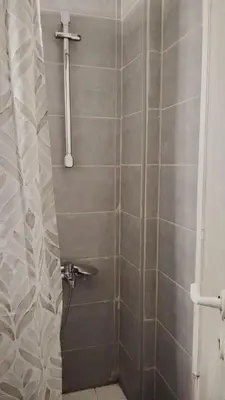 a bathroom with a shower with a cross on the wall at Hidden Gem in the Heart of City in Athens