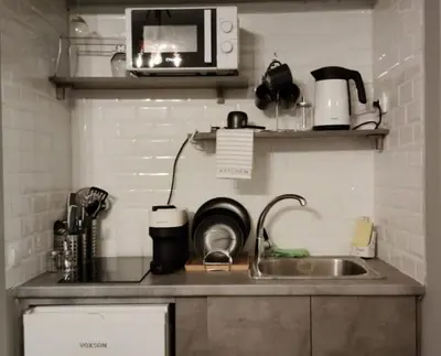 a kitchen counter with a sink and a microwave at Hidden Gem in the Heart of City in Athens