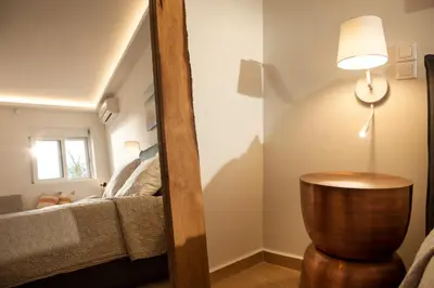 a mirror in a room with a bed and a table at Vouliagmeni Bay Stylish house with private garden in Athens