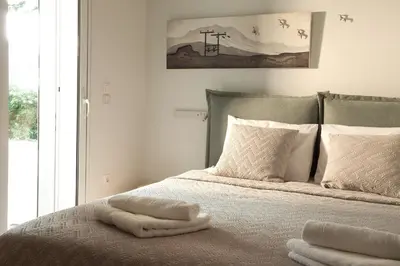 a bedroom with a bed with towels on it at Vouliagmeni Bay Stylish house with private garden in Athens