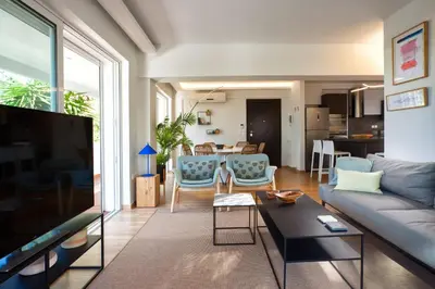 a living room with a couch and a table at Vouliagmeni Bay Stylish house with private garden in Athens
