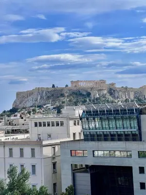 a view of the acropolis from a city with buildings at Acropolis Open Sky Family by Zeus Suites in Athens