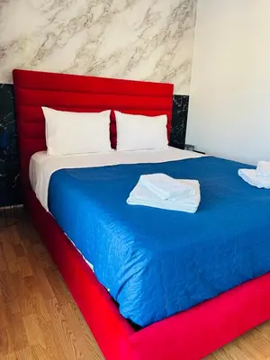a large bed with a red and blue blanket at Acropolis Open Sky Family by Zeus Suites in Athens