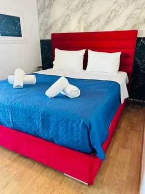 a red and blue bed with two towels on it at Acropolis Open Sky Family by Zeus Suites in Athens