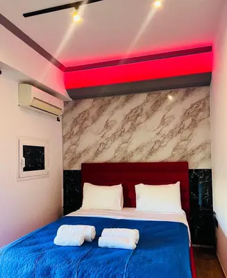 a bedroom with a blue bed with a red ceiling at Acropolis Open Sky Family by Zeus Suites in Athens