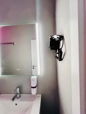 a bathroom with a sink and a mirror and a camera at Acropolis Open Sky Family by Zeus Suites in Athens