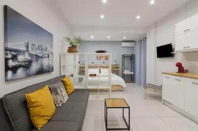 a living room with a couch and a bedroom at A little gem in the heart of Athens in Athens