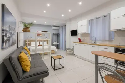 a kitchen and living room with a couch and a table at A little gem in the heart of Athens in Athens