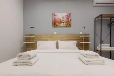 a bedroom with a large white bed with towels on it at A little gem in the heart of Athens in Athens