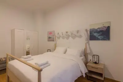 a bedroom with a white bed with white sheets at Heaven apartment in the heart of Athens in Athens