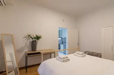 a bedroom with a bed and a vase of flowers on a table at Heaven apartment in the heart of Athens in Athens