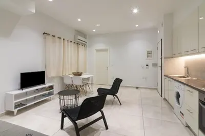 a kitchen with chairs and a table and a tv at Heaven apartment in the heart of Athens in Athens