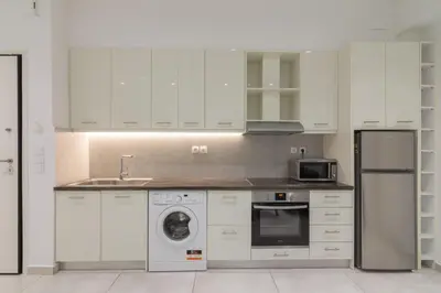 a kitchen with white cabinets and a sink and a dishwasher at Heaven apartment in the heart of Athens in Athens