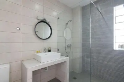 a bathroom with a sink and a glass shower at Sunny paradise in the heart of Athens in Athens