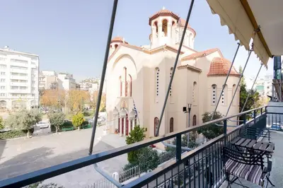a church with a clock tower on a balcony at Sunny paradise in the heart of Athens in Athens