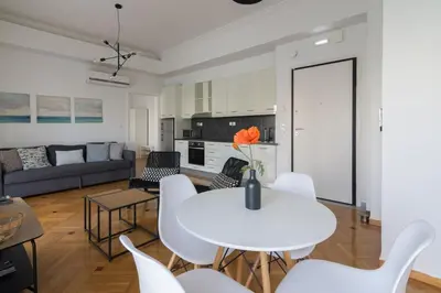 a living room with a white table and white chairs at Sunny paradise in the heart of Athens in Athens