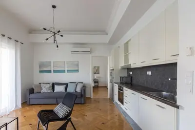 a kitchen and a living room with a couch at Sunny paradise in the heart of Athens in Athens