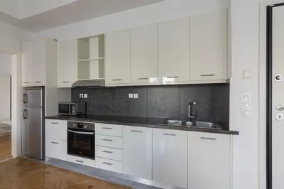 a white kitchen with white cabinets and a sink at Sunny paradise in the heart of Athens in Athens