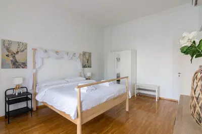 a bedroom with a white bed and a wooden floor at Sunny paradise in the heart of Athens in Athens