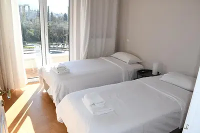 two white beds in a room with a window at Adrianos Gate View Apartment in Athens