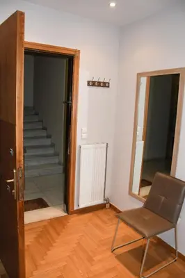 a room with a door and a chair and stairs at Adrianos Gate View Apartment in Athens