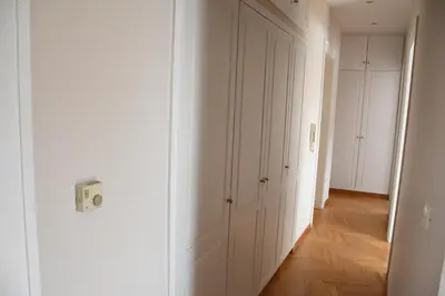 a hallway with white closets and a hallway with wood floors at Adrianos Gate View Apartment in Athens