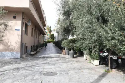 an empty street with trees and plants on the side of a building at Adrianos Gate View Apartment in Athens