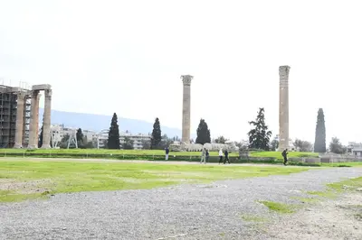 a group of people standing in a field with two smoke stacks at Adrianos Gate View Apartment in Athens