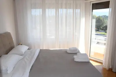 a bedroom with a bed and a large window at Adrianos Gate View Apartment in Athens