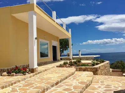 a house with a stone walkway next to a building at Casa Arsida in Anavissos