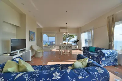 a living room with a blue couch and a tv at Casa Arsida in Anavissos