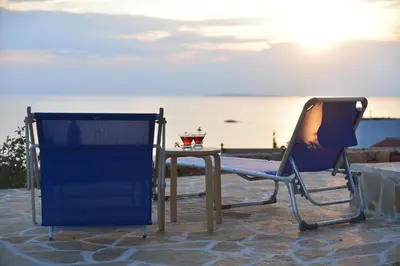 two chairs and a table with a drink on it at Casa Arsida in Anavissos