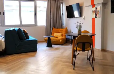 a living room with a table and a chair at Athens Central Suites Retreat in Athens