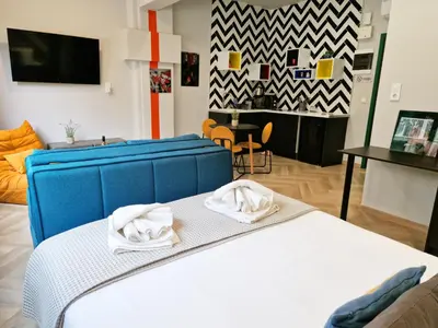 a bedroom with a blue bed with towels on it at Athens Central Suites Retreat in Athens