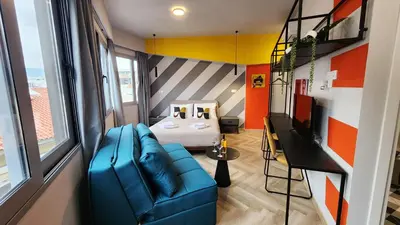 a living room with a blue couch and a bedroom at Athens Central Suites Retreat in Athens