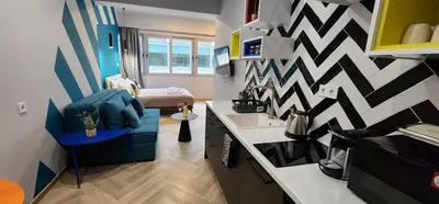 a room with a blue chair and a geometric wall at Athens Central Suites Retreat in Athens