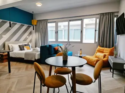 a living room with a couch and a table and chairs at Athens Central Suites Retreat in Athens