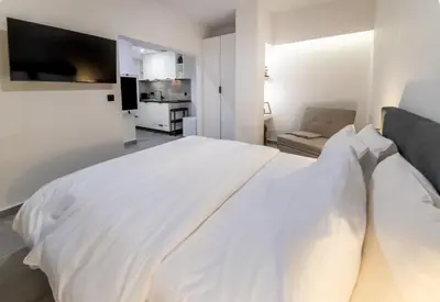 a white bedroom with a large white bed at Athenian Kolonaki Apartment in Athens