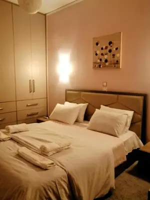 a bedroom with a large bed with white sheets and pillows at Raffaella Athens in Athens