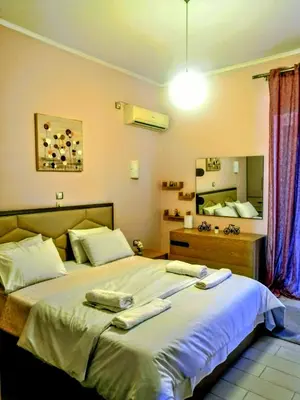 a bedroom with a large bed with towels on it at Raffaella Athens in Athens